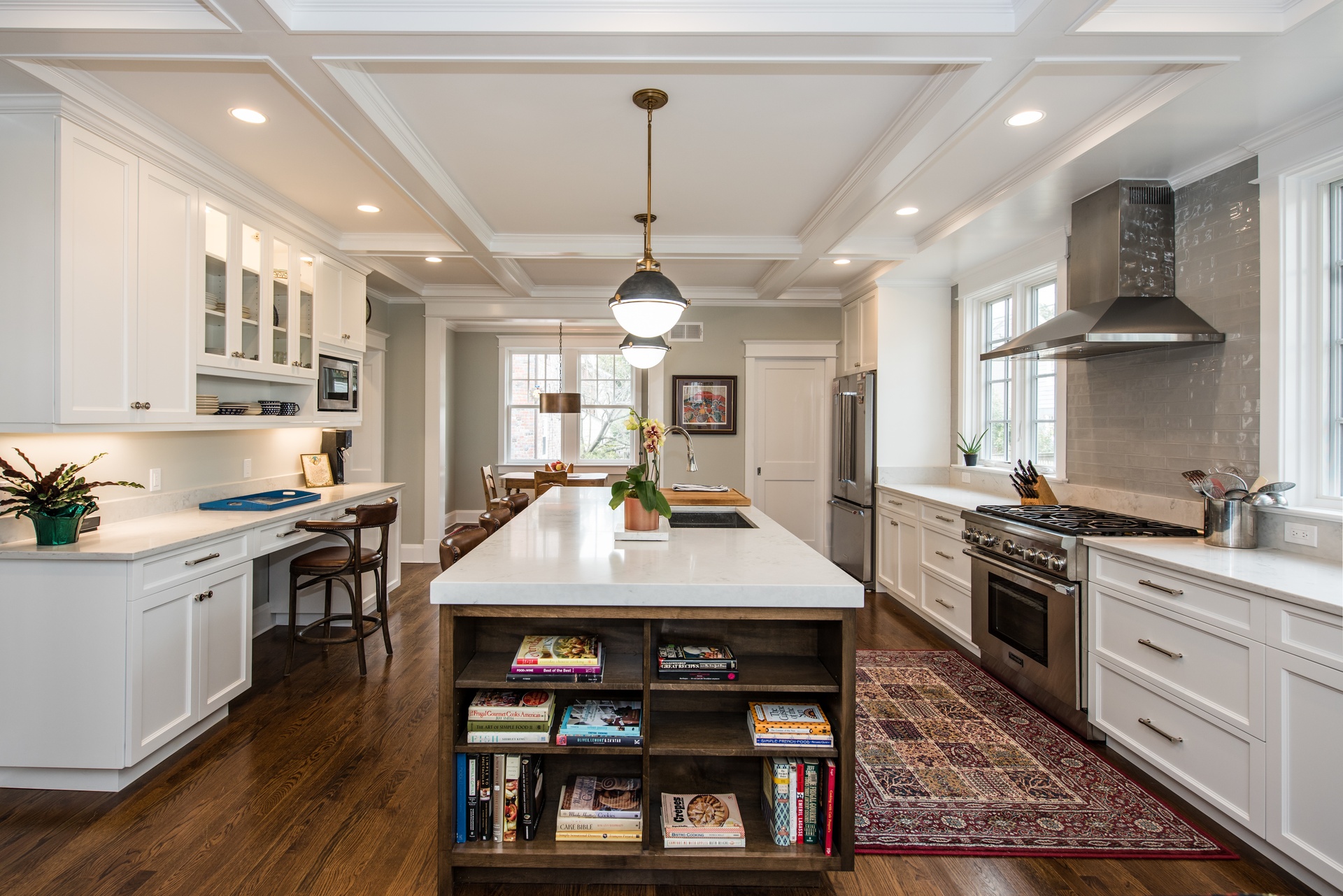 FineCraft custom kitchen with coffered ceiling, white cabinetry, and a large wood island