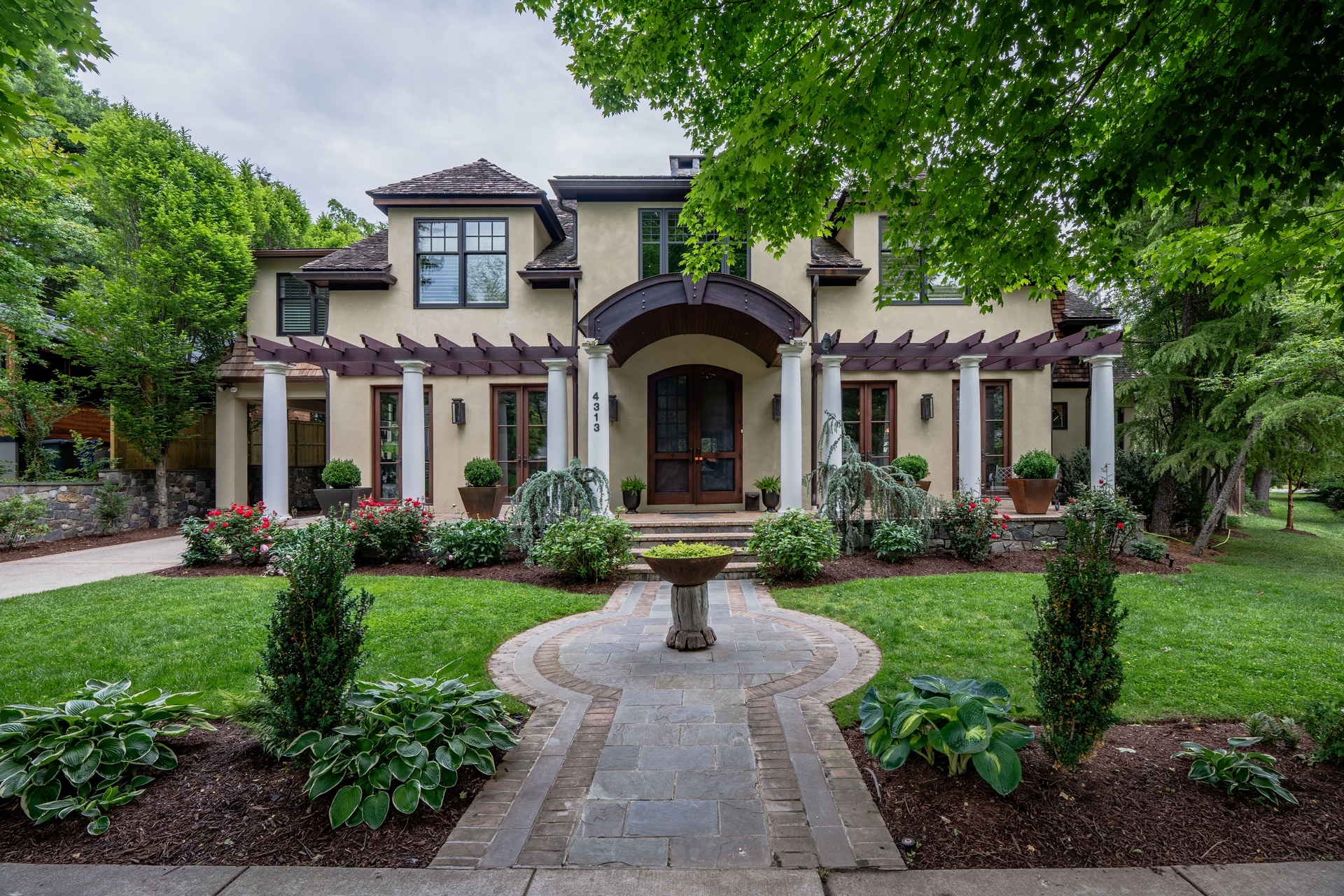 FineCraft custom home exterior framed by mature trees and landscaped gardens