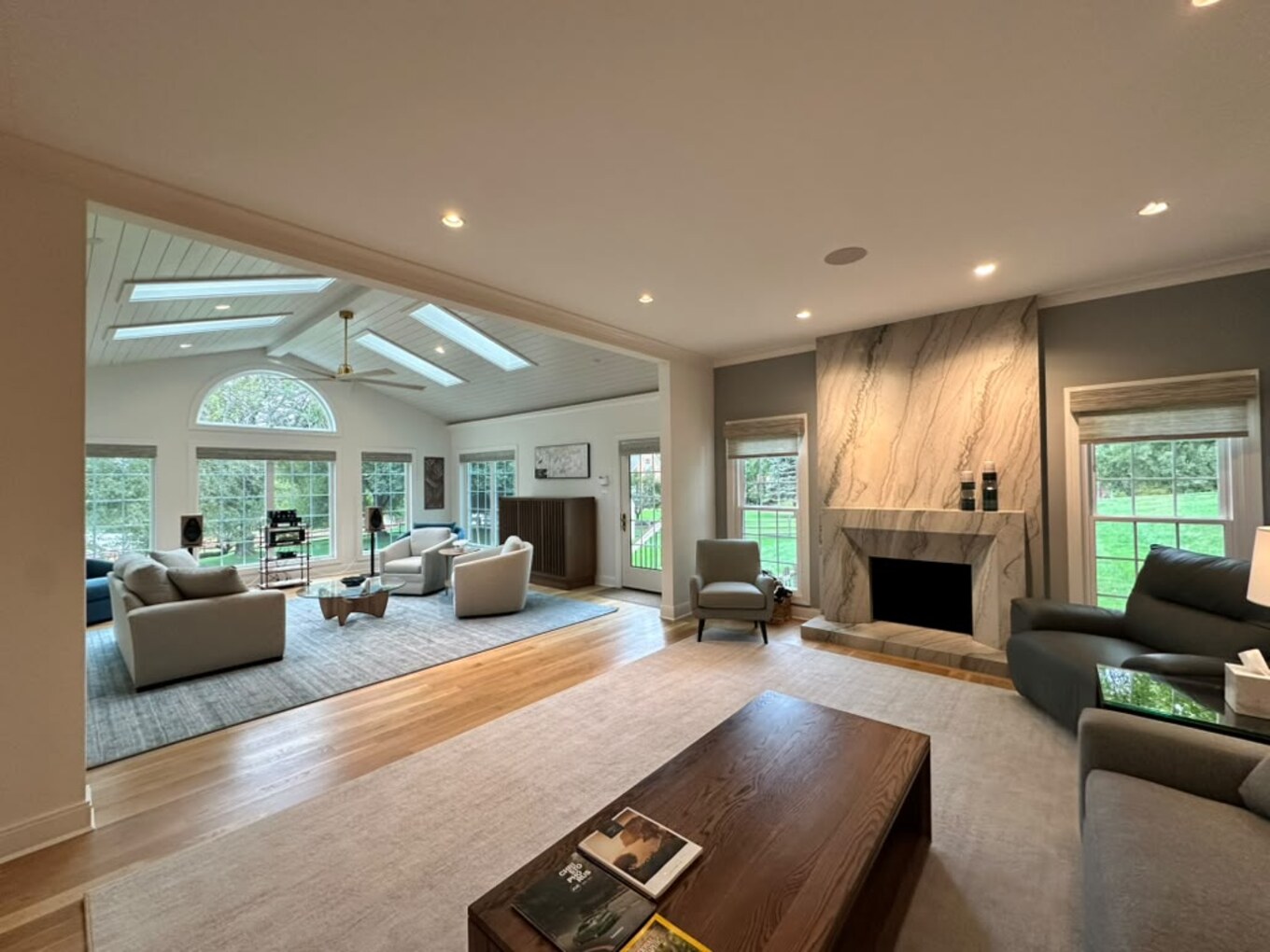 Light-filled FineCraft family room with a sculptural stone fireplace, skylights, and views to the garden.