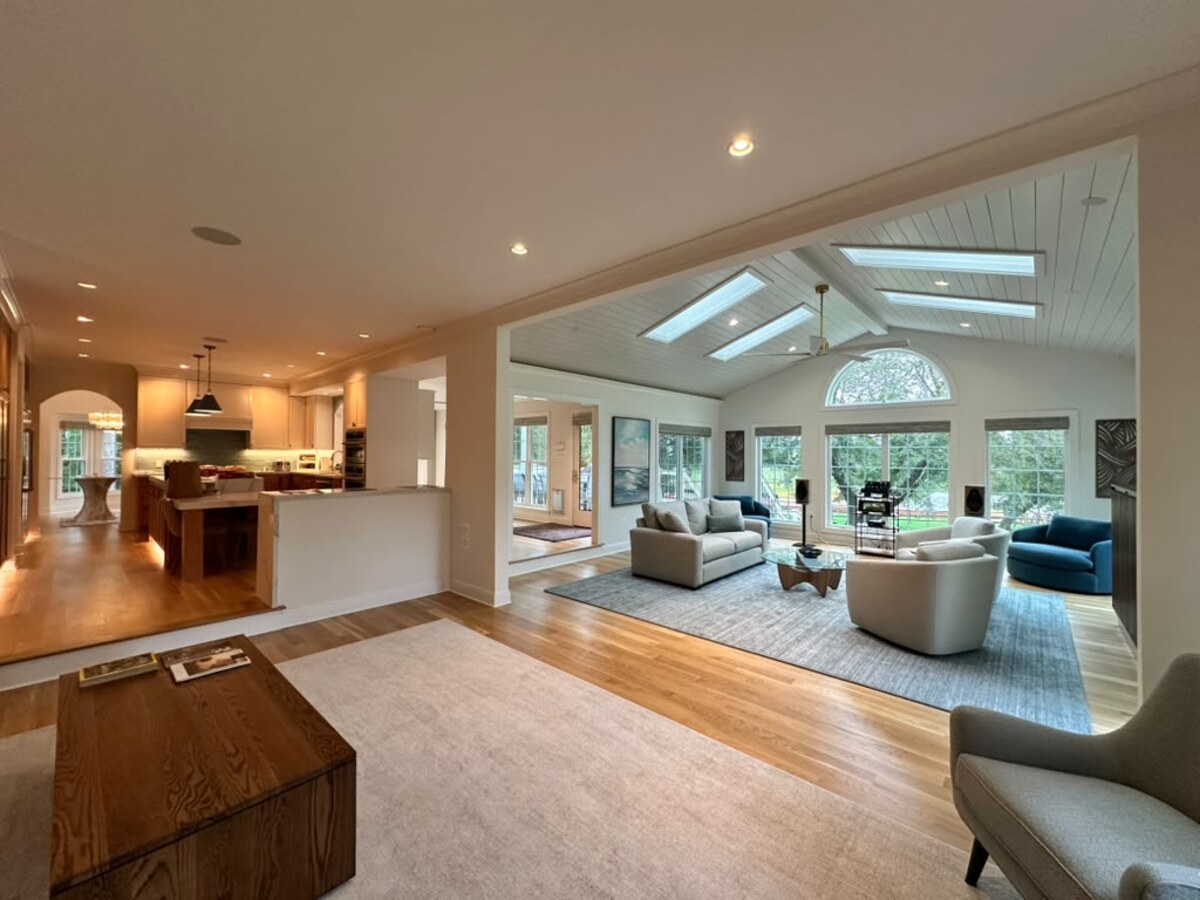 FineCraft open-plan home connecting a warm wood kitchen with a bright family room and garden views.