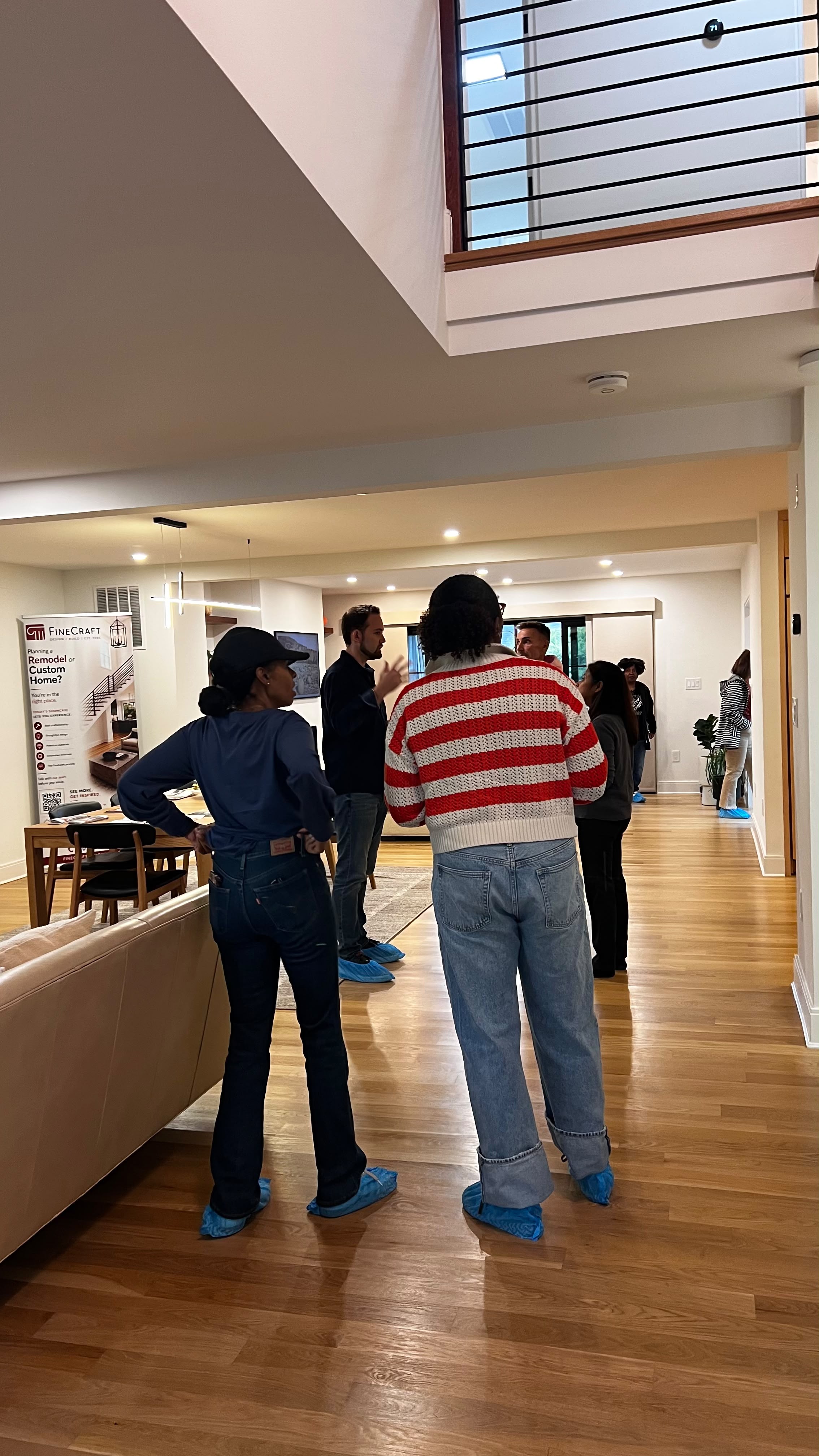 Visitors exploring the bright interior beneath the stairwell and upper-level railing.